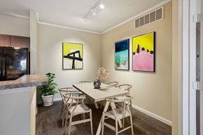 Seguin apartment for rent - A dining room with a table and chairs and three paintings on the wall.